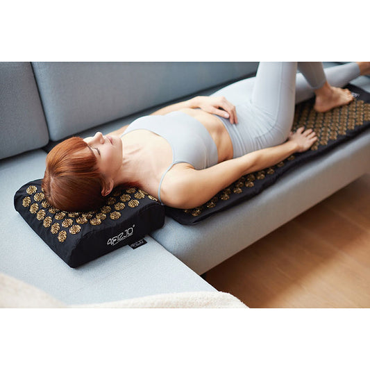 Mergina atsigulusi ant didelio akupresūrinio taškinio masažo kilimėlio