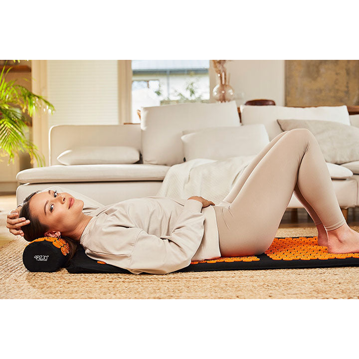 Mergina guli ant didelio klasikinio akupunktūrinio masažo kilimėlio
