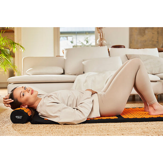 Mergina guli ant didelio klasikinio akupunktūrinio masažo kilimėlio
