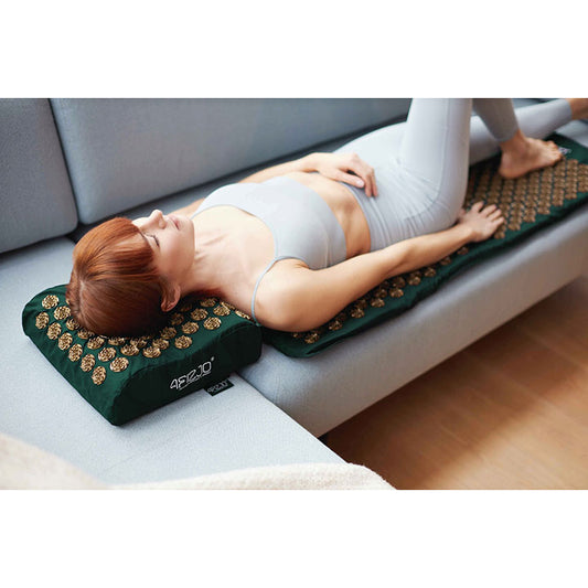 Jauna mergina masažuoja nugarą ir kaklą ant 4FIZJO didelio masažinio akupresūros kilimėlio