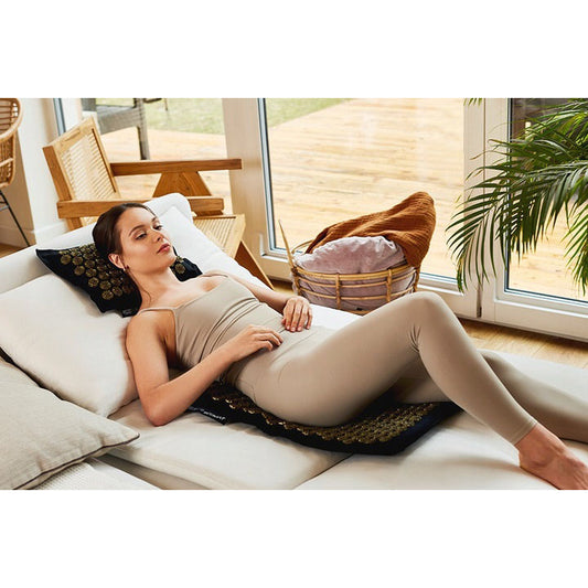 Mergina guli ant ECO masažinio kilimėlio nugarai